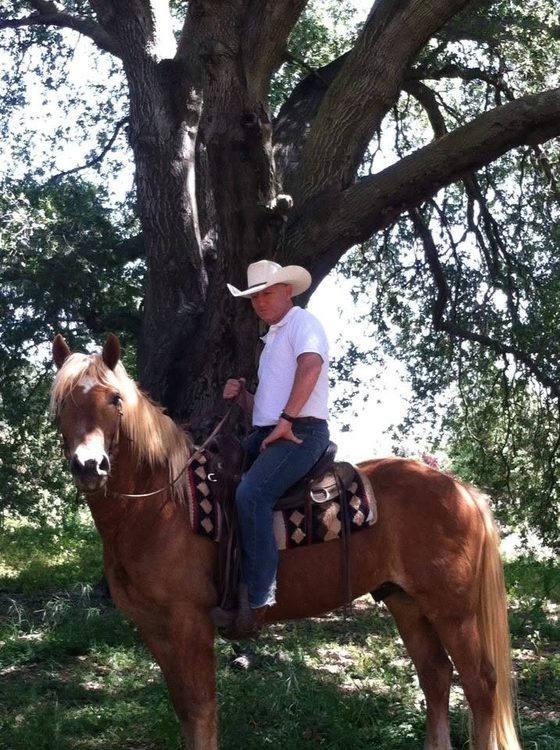 Serge Cohen on horseback under an old oak tree