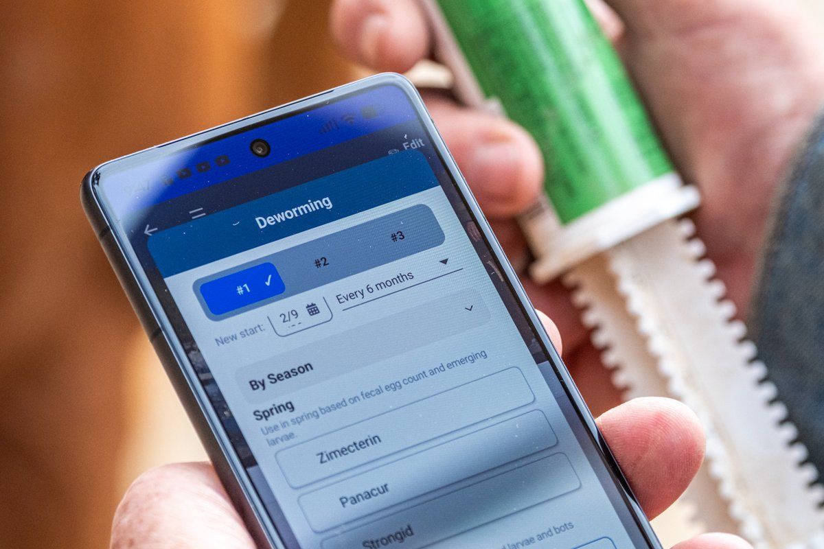 A rider holds a dewormer tube while picking the next dose in EquiNex, browsing by season with three dewormer slots: a horse deworming schedule app in use